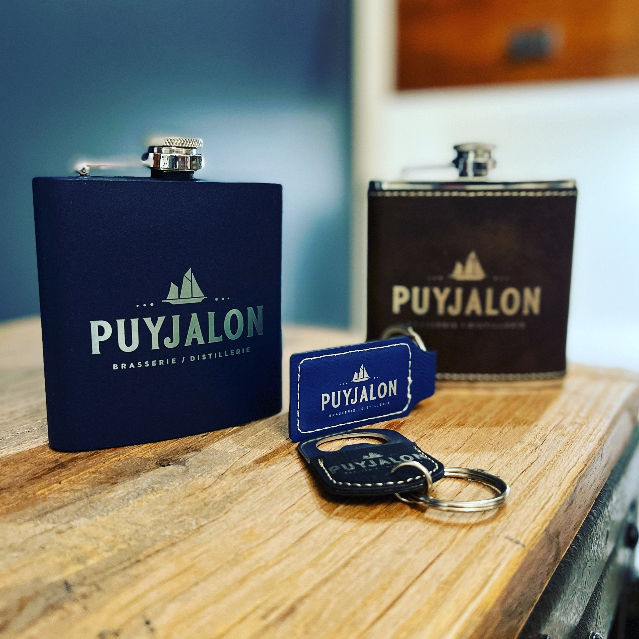 2 flasques dont un marine et un brun avec un porte-clé personnalisés au nom de la distillerie Puyjalon - BoisFrancK