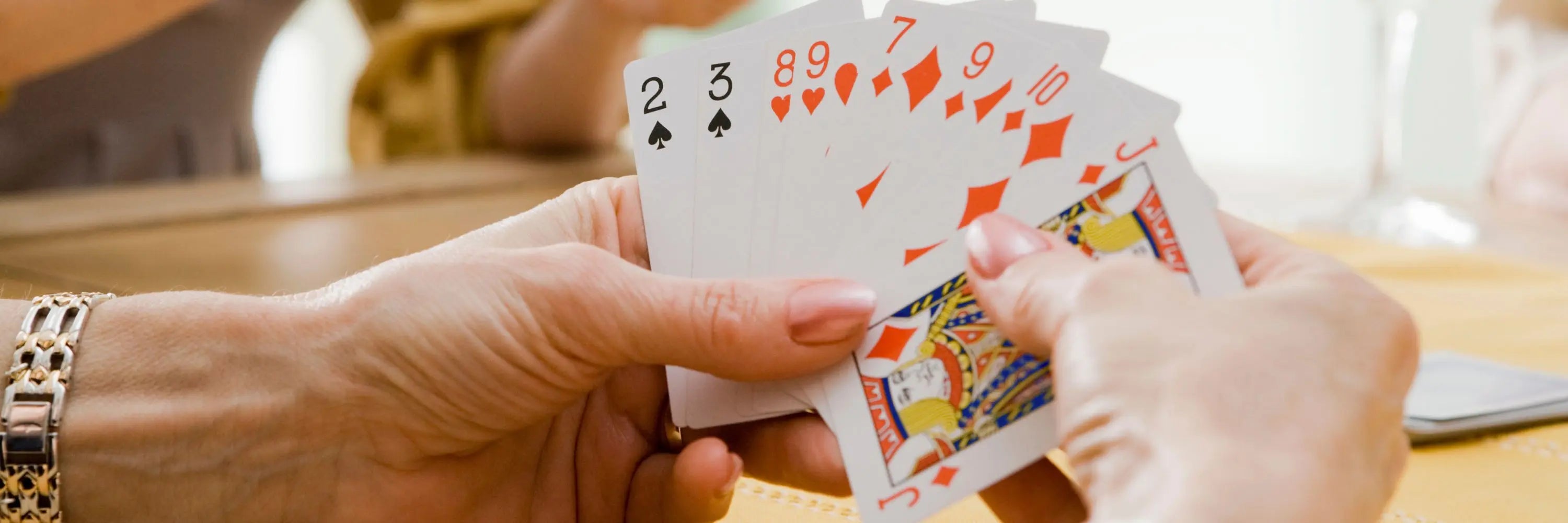 gros plan sur des mains tenant des cartes-jeux de société