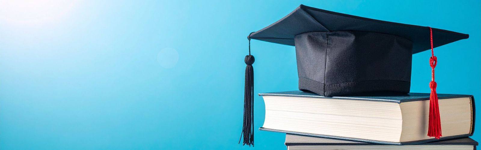 chapeau de graduation sur une pile de livres - cadeaux de graduation collection