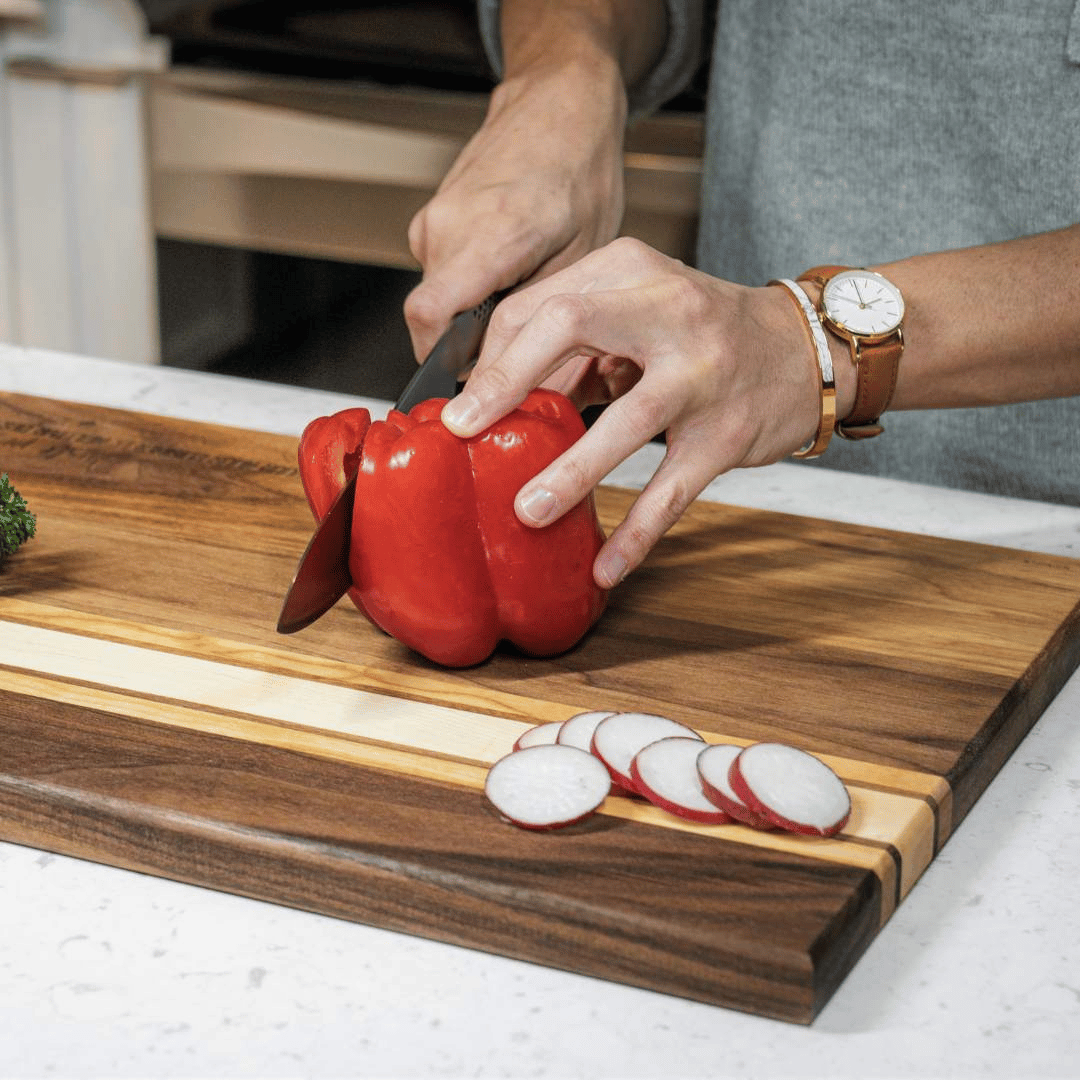 Photo_d_une_cliente_decoupant_des_legumes_sur_sa_planche_a_decouper_personnalisee_au_Qc-BoisFranck