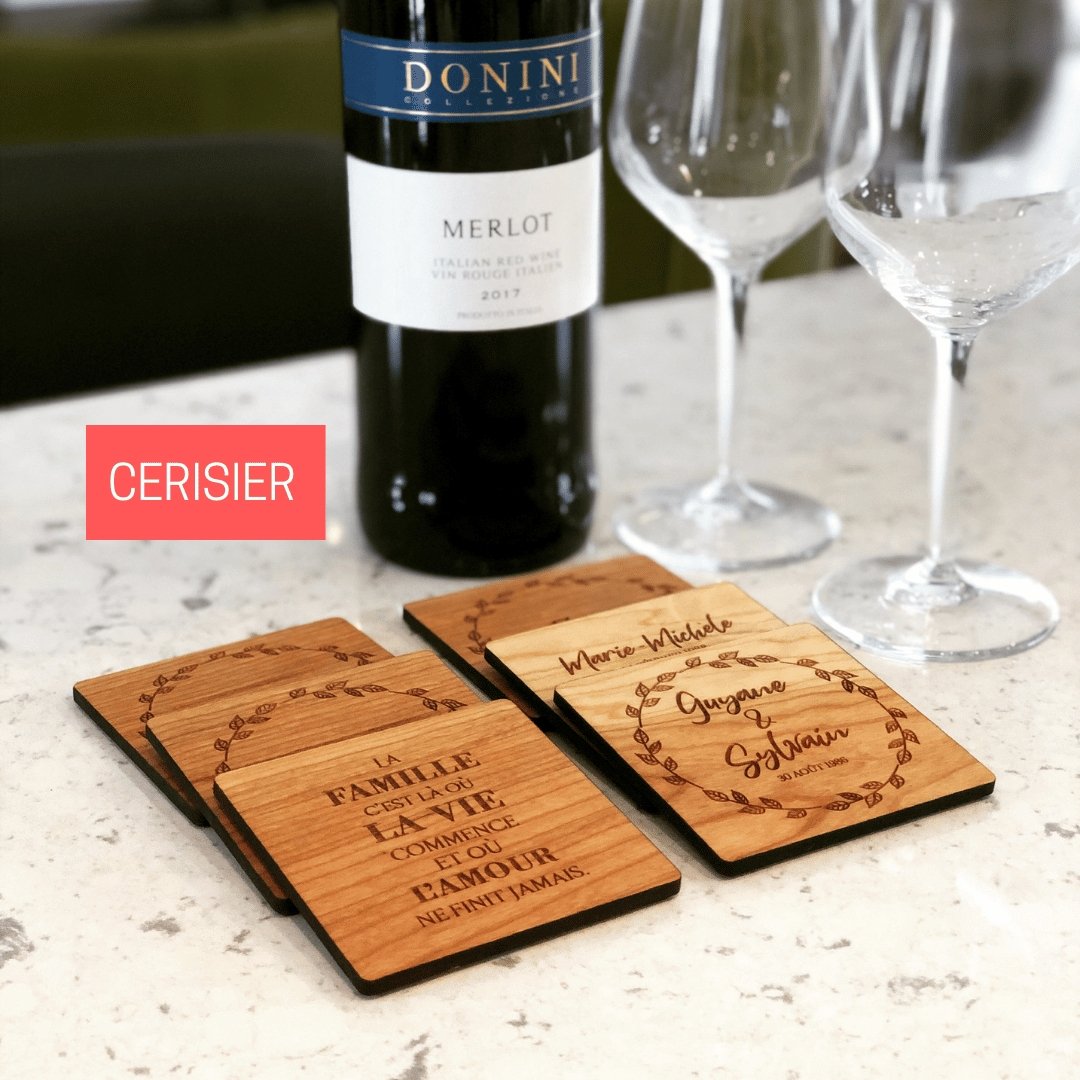 Lot de sous-verres personnalisés en cerisier sur un comptoir avec bouteille de vin et coupes- BoisFrancK